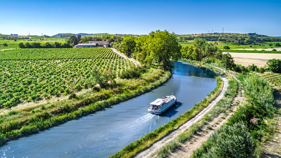 Aerial drone view of houseboat in Canal du Midi from above, fami